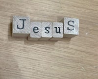 a wooden block with the word jesus on it